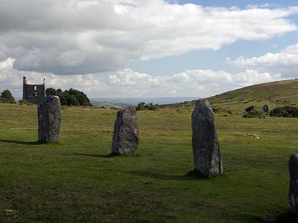 Part of The Hurlers stone circle with Phoenix Mine and Caradon Hill in the background